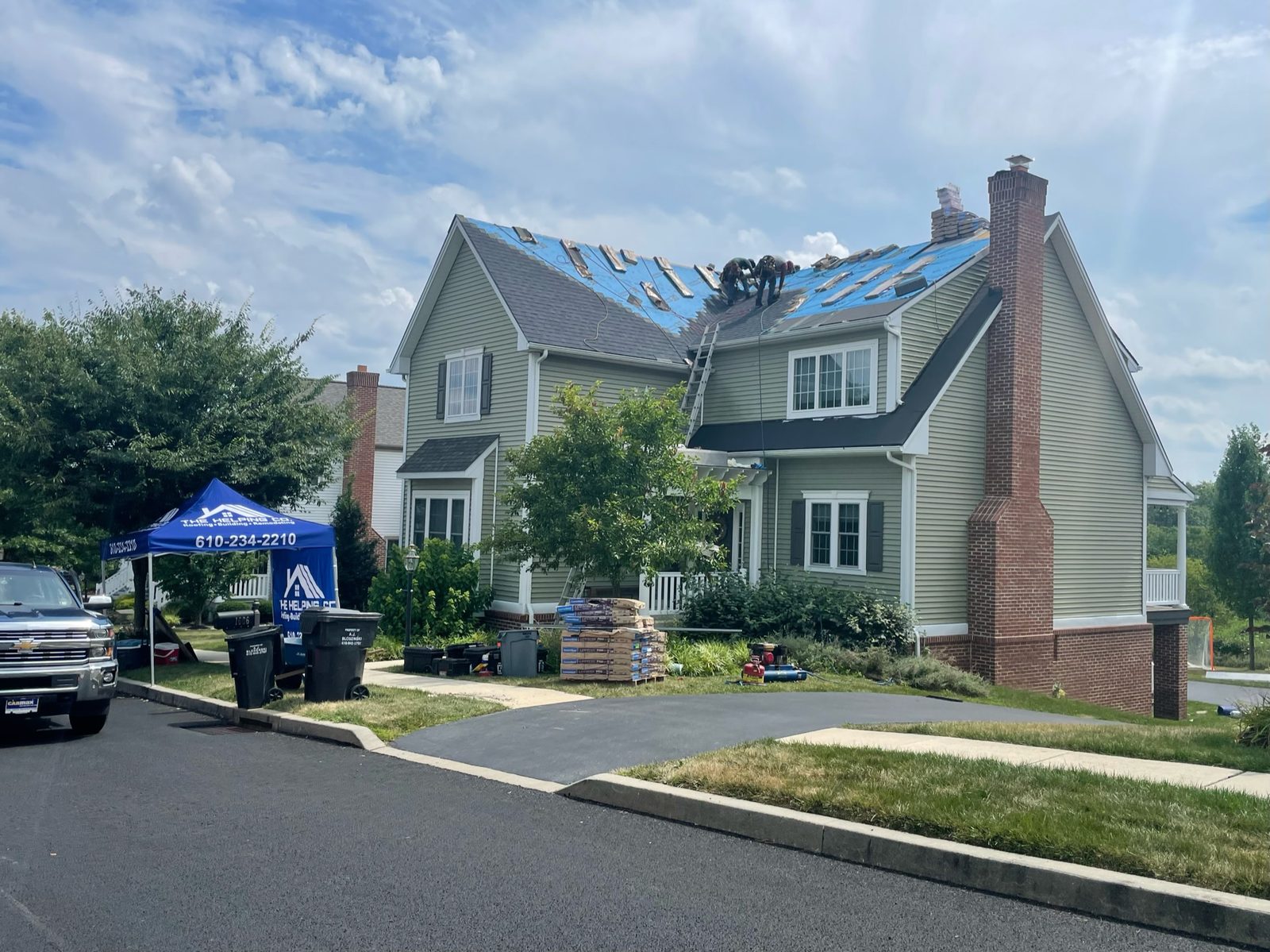 Blue emergency roof tarps after hail and storm damage in a Berks County, PA neighborhood