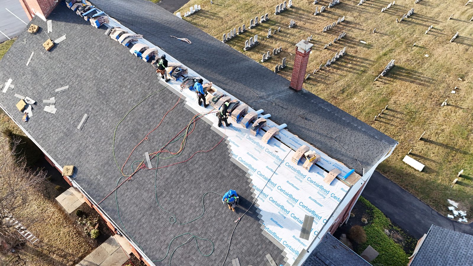 Roofing crew working on a low-slope commercial roof section in New Holland, Pennsylvania