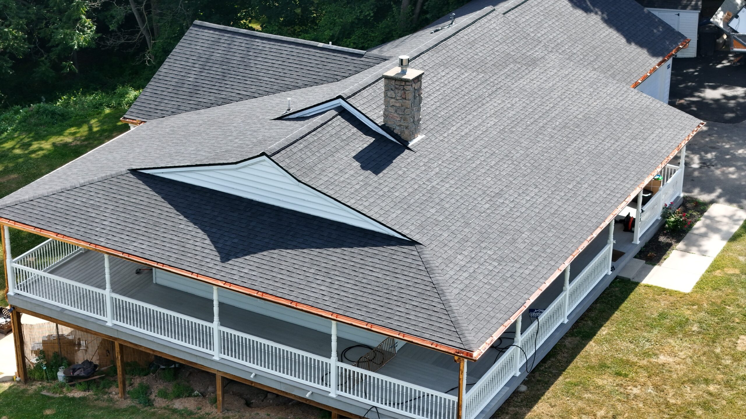 Aerial shot of home with wraparound porch and new shingled roof